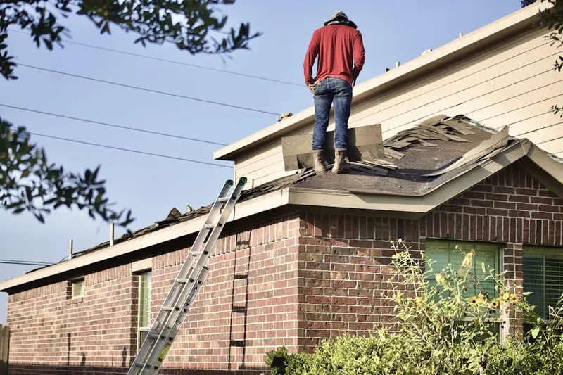 Professional roofer working on a residential roof in Postville
